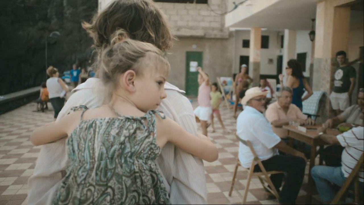 Una niña se refugia en un abrazo entre gente de su comunidad