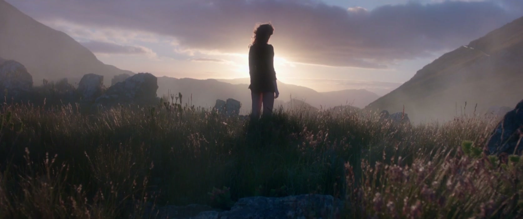 Una persona contempla un valle de montaña al amanecer