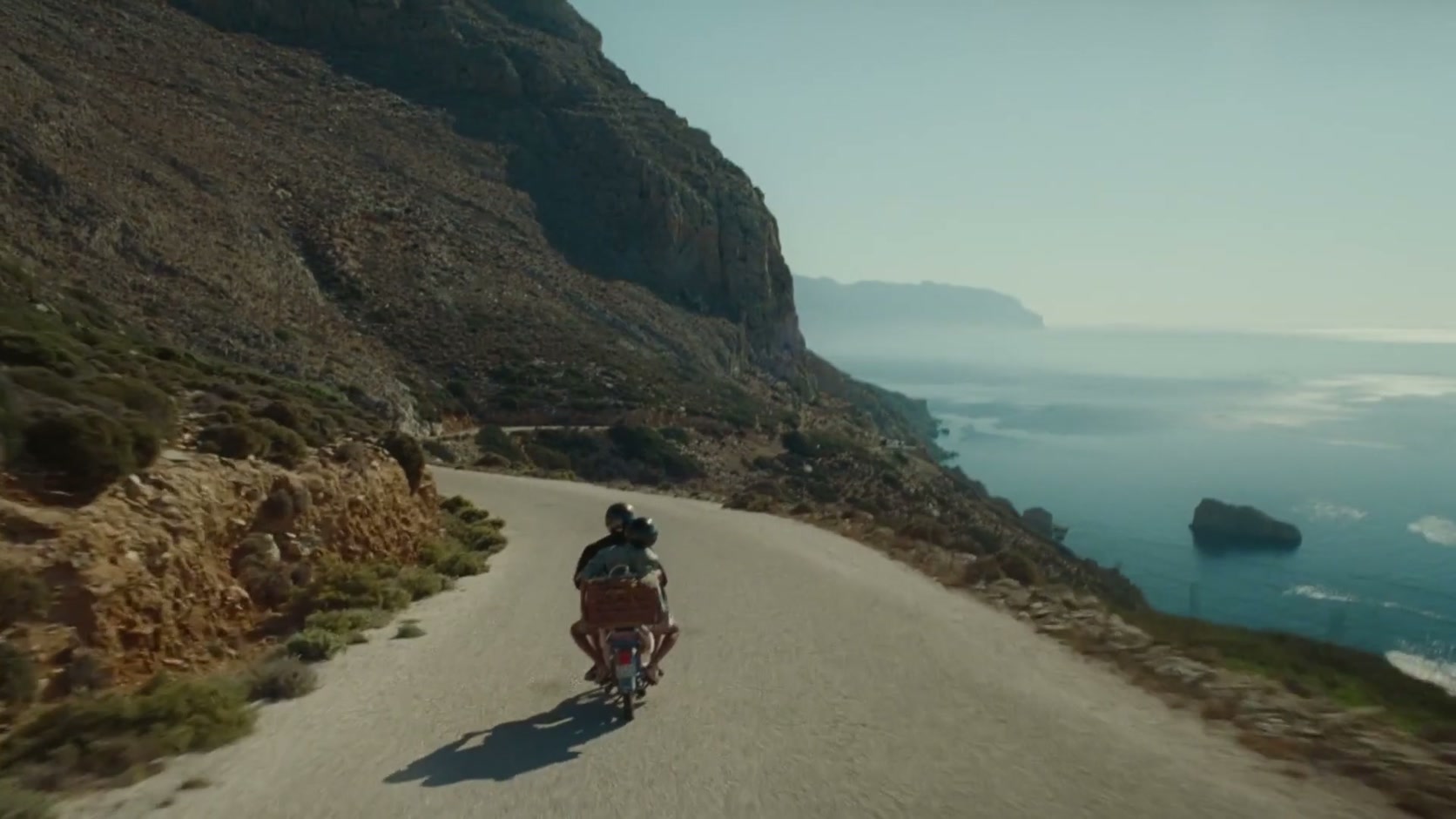 Una carretera recorre la costa entre montaña y océano