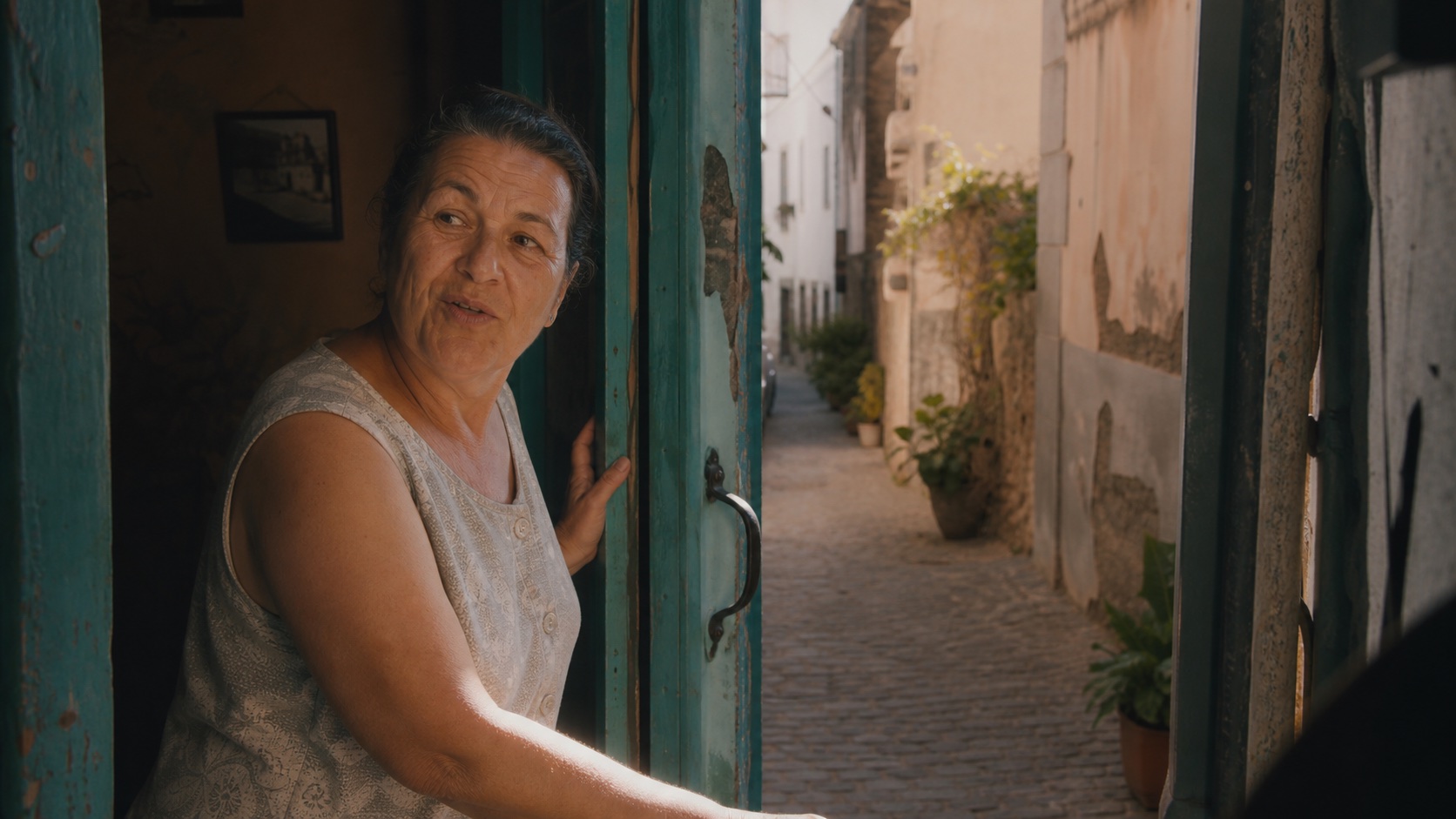 Una vecina se asoma a una calle de un pueblo de la isla
